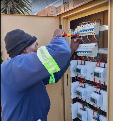 Professional electrician working on distribution board